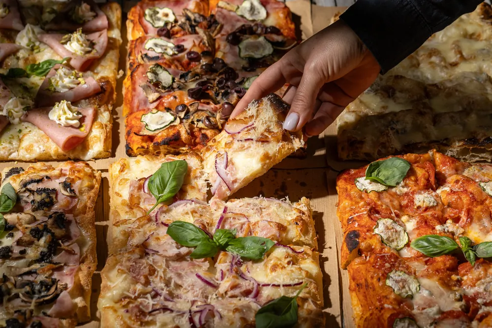 Pizza în tavă din aluat propriu, felii pe hârtie
